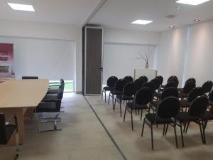 a conference room with chairs and a table and a screen at RENTAL SUITES CAMPANA in Campana