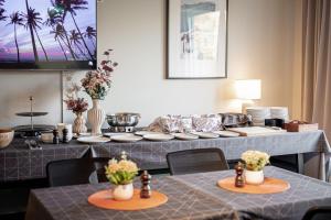 a dining room with two tables with plates and flowers at First Hotel Uppsala East in Uppsala +47 photos