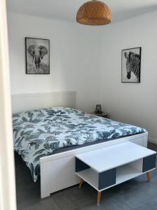 une chambre avec un lit avec une couverture bleue et une table dans l'établissement Les Tamaris, à Arles