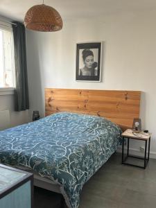 une chambre avec un lit avec une tête de lit en bois dans l'établissement Les Tamaris, à Arles