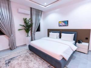 a bedroom with a large bed with white sheets at Aurum on Missouri in Abuja