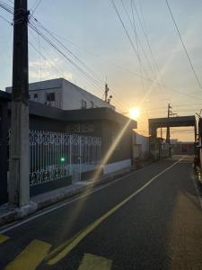 an empty street with the sun setting behind a building at House for rent in Residencial Santo Antônio in Belém