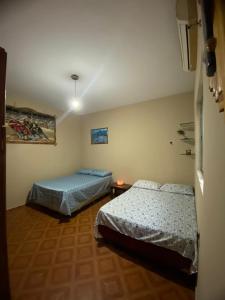 a bedroom with two beds and a table in it at House for rent in Residencial Santo Antônio in Belém