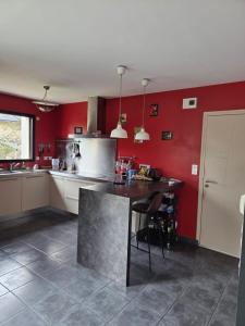 una cocina con paredes rojas y una mesa. en Dany propose colocation, chambre Lannion, en Lannion