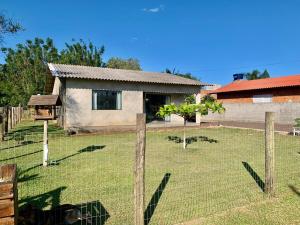 a house with a fence in a yard at Cada na Praia Itapeva Torres in Torres