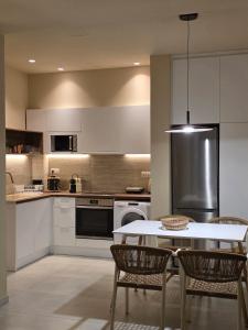 a kitchen with a table and chairs and a refrigerator at Rastoni Suites Xylokastro 1 in Melission