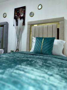 a bedroom with a bed with a blue pillow at Casa De Las Muñecas RH in Santo Domingo