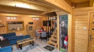 een woonkamer met een beer foto aan de muur bij Domek u Pusi z jacuzzi in Solina