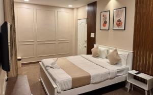ein Schlafzimmer mit einem Bett und einem Fernseher in der Unterkunft Zephyr Inn Pondy in Puducherry