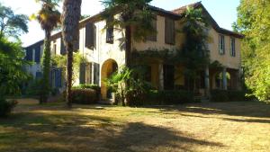 an old house with palm trees in front of it at Maison Doat 1823 in Perchède