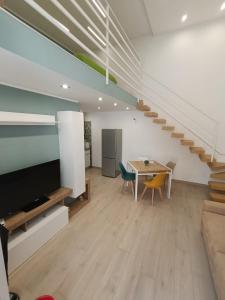 a living room with a table and a staircase at AparthouseRisorgimento BORBONE in Frattamaggiore