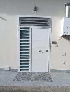 a white garage with a door and a window at AparthouseRisorgimento BORBONE in Frattamaggiore