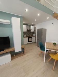 a kitchen and a dining room with a table and a television at AparthouseRisorgimento BORBONE in Frattamaggiore