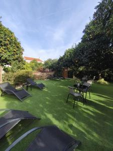 a yard with tables and chairs on the grass at Casa do Chafariz - Rooms in Cercal +47 photos