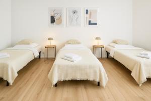 una camera con tre letti e due tavoli di Airport-Messe Apartments a Dusseldorf