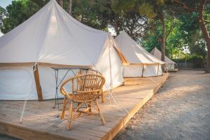eine Zeltreihe mit einem Tisch und einem Stuhl in der Unterkunft HolaCamp Sant Salvador in Comarruga + 30 Fotos