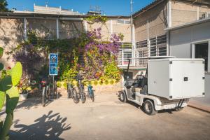 Ein Auto parkt vor einem Gebäude mit Fahrrädern. in der Unterkunft HolaCamp Sant Salvador in Comarruga