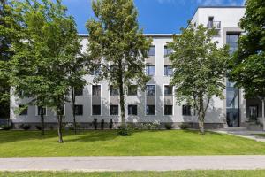 an apartment building with trees in front of it at Lauvas Rezidences - Self check-in in Rīga