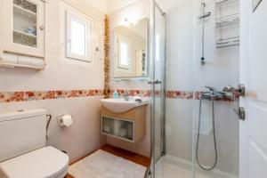 a bathroom with a shower and a toilet and a sink at Villa Meliti Paros in Angairiá +30 photos