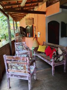 a porch with two benches and a table and chairs at Pousada João e Maria in Trindade