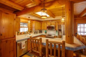 a large kitchen with wooden walls and wooden cabinets at Rustic Gotham Bay Cabin on Lake Coeur dAlene in Harrison