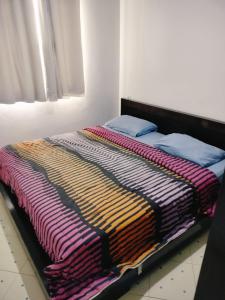 タンジェにあるComfortable apartmentのカラフルな毛布が備わるベッド1台