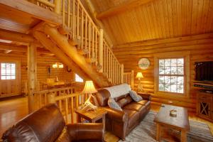 a living room with a leather couch in a log cabin at Rustic Gotham Bay Cabin on Lake Coeur dAlene in Harrison