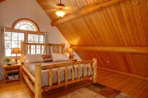 a bedroom with a bed in a room with wooden walls at Rustic Gotham Bay Cabin on Lake Coeur dAlene in Harrison