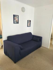 a blue couch in a room with two pictures on the wall at Noruega in La Serena