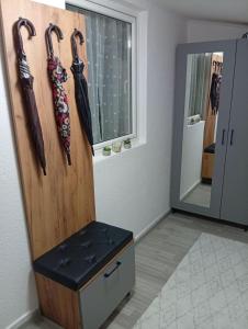 a wooden cabinet with umbrellas hanging on a wall at Apartman Mali kutak in Gradačac