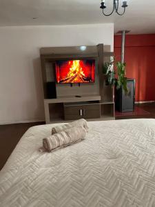 a large bed in a room with a tv at Hostal lynch in Osorno