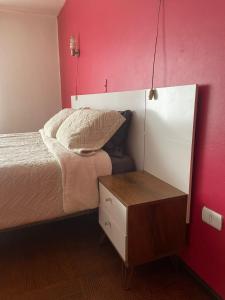 a small bedroom with a bed and a night stand at Hostal lynch in Osorno
