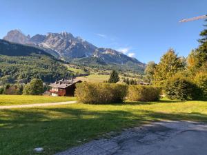 a house in a field with mountains in the background at Ra Geralbes in Cortina dʼAmpezzo