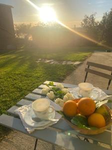 a table with a plate of fruit and cups on it at Casa Vilamarín in Santa Eulalia