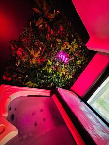 een badkuip gevuld met bloemen in een roze kamer bij Nid’Ange in Piolenc +12 foto's