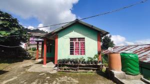a small house with a red window and some plants at Nimbus Soulstay in Kalimpong +22 photos