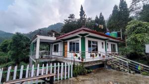 a small house with a fence in front of it at Nimbus Soulstay in Kalimpong