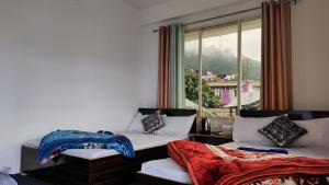 a room with two beds and a window with a view at Nimbus Soulstay in Kalimpong