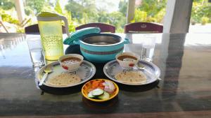 a table with three plates of food and cups of coffee at Nimbus Soulstay in Kalimpong
