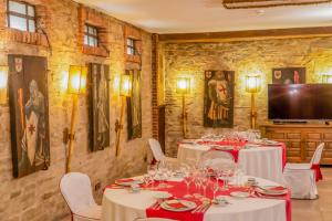 a restaurant with white tables and chairs and a flat screen tv at Hotel Temple Ponferrada in Ponferrada