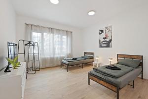 ein Wohnzimmer mit zwei Betten und einer Couch in der Unterkunft PF04 Großzügiges City Apartment für Monteure - LS Crew Comfort DIE Adresse für Monteure in Pforzheim