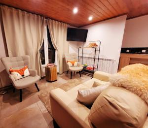 ein Wohnzimmer mit einer Couch und zwei Sesseln in der Unterkunft Chalé Zimbro, Serra da Estrela, Penhas da Saúde in Penhas da Saúde + 38 Fotos