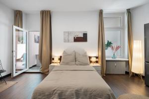een slaapkamer met een groot bed en twee ramen bij Loftly 5min zu Fuß Charite - 45m2 - Self Check-In - 300mbit in Berlijn