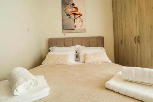 a bedroom with a bed with white sheets and pillows at BALLET MAISON in the heart of the city in Alexandroupoli
