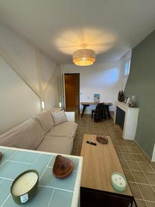 a living room with a couch and a table at L'Appart du Coq - Proche du Zoo de Beauval & des châteaux in Selles-sur-Cher +9 photos