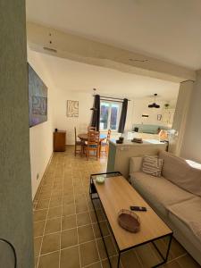 a living room with a couch and a table at L'Appart du Coq - Proche du Zoo de Beauval & des châteaux in Selles-sur-Cher