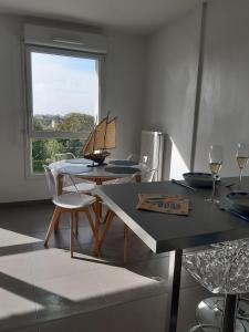 a dining room with a table and chairs and a window at Charmant studio vue dunes à 400m de la plage in Dunkerque