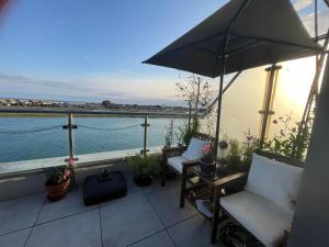 a balcony with two chairs and an umbrella at Special Occasion, Stunning sea view balconied suite in Shoreham-by-Sea
