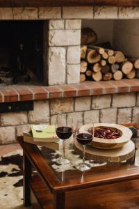 two glasses of red wine on a table with a fireplace at Arcinazzohouse in Canterano