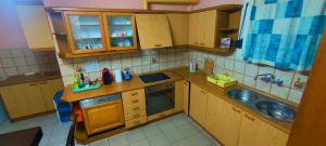 a small kitchen with wooden cabinets and a sink at Kounis Villa in Chalkida